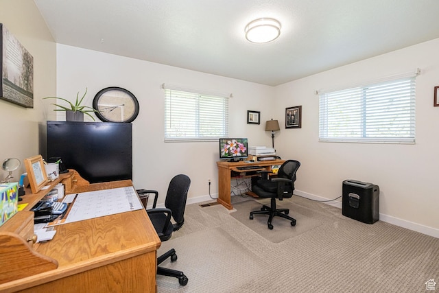 office space with baseboards, carpet flooring, and a healthy amount of sunlight