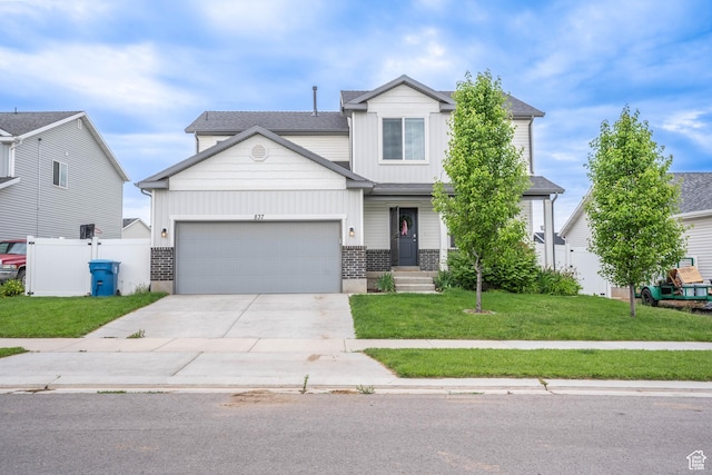 view of front of house with concrete driveway, a front lawn, an attached garage, fence, and brick siding