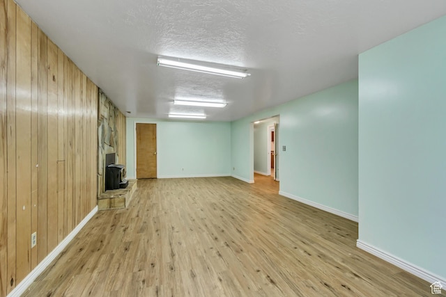 3916 S Hawkeye Dr, West Valley City, UT 84120 - interior space featuring wooden walls, baseboards, a wood stove, and light wood finished floors