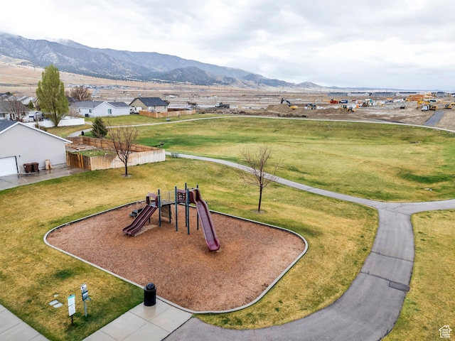 communal playground featuring a lawn and a mountain view