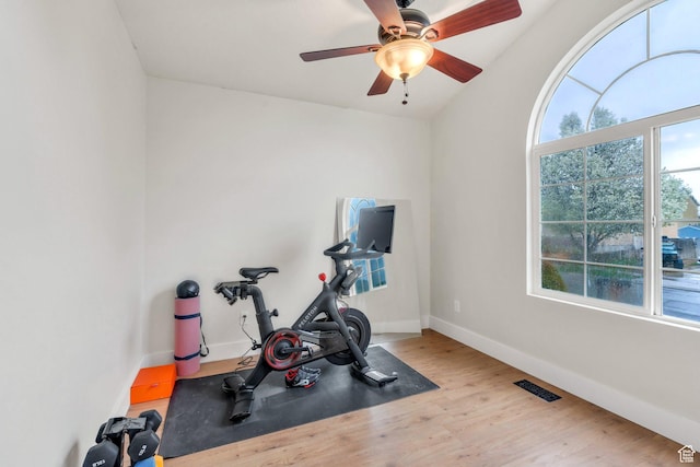 workout area featuring wood finished floors, visible vents, a ceiling fan, and baseboards