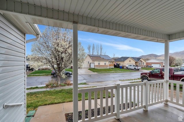 view of patio with a residential view, a porch, and a mountain view