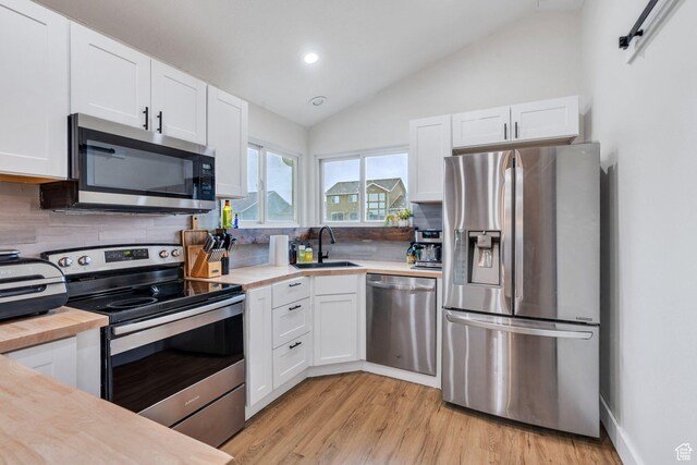 kitchen featuring white cabinets, a sink, appliances with stainless steel finishes, and tasteful backsplash