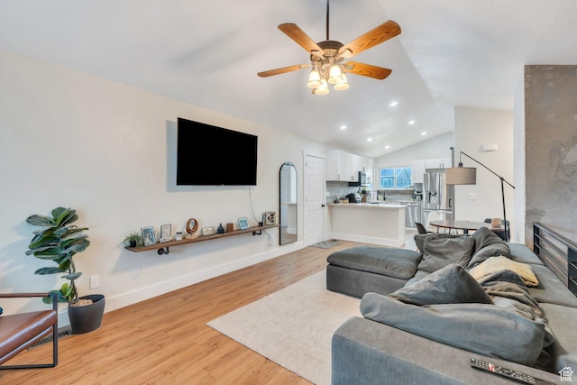 living room with recessed lighting, lofted ceiling, light wood finished floors, a ceiling fan, and baseboards