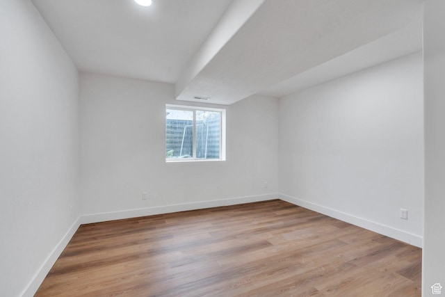 empty room with baseboards, light wood-style flooring, and visible vents