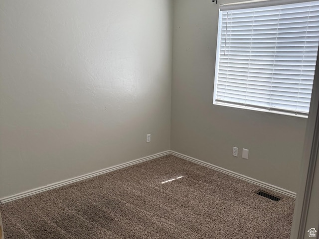unfurnished room featuring carpet floors, visible vents, and baseboards