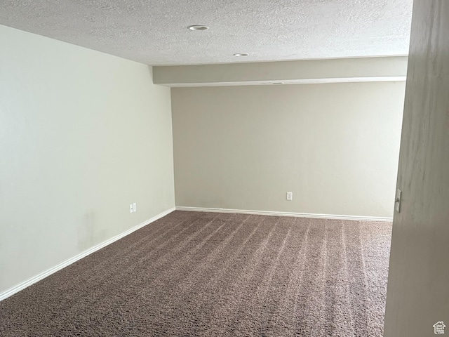 carpeted spare room with baseboards and a textured ceiling