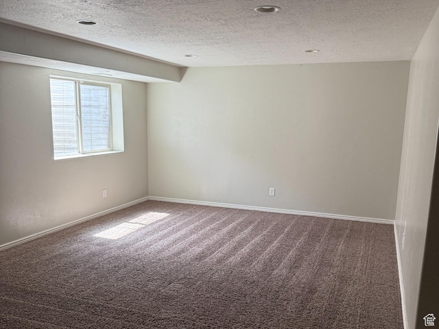 carpeted empty room with a textured ceiling and baseboards