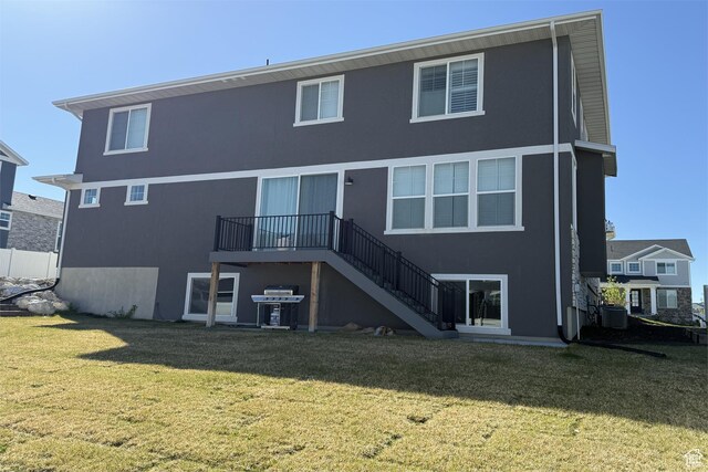 6129 W Coulee Ln, West Jordan, UT 84081 - rear view of property featuring stucco siding, a lawn, central AC, and stairway