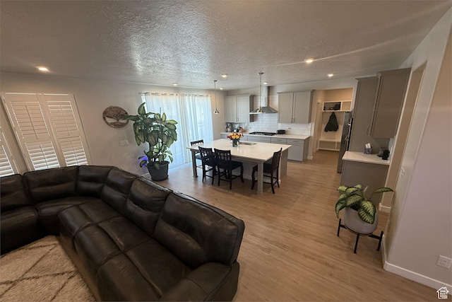 6129 W Coulee Ln, West Jordan, UT 84081 - living room with light wood finished floors, a textured ceiling, and recessed lighting