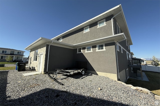 6129 W Coulee Ln, West Jordan, UT 84081 - rear view of house featuring stone siding and stucco siding