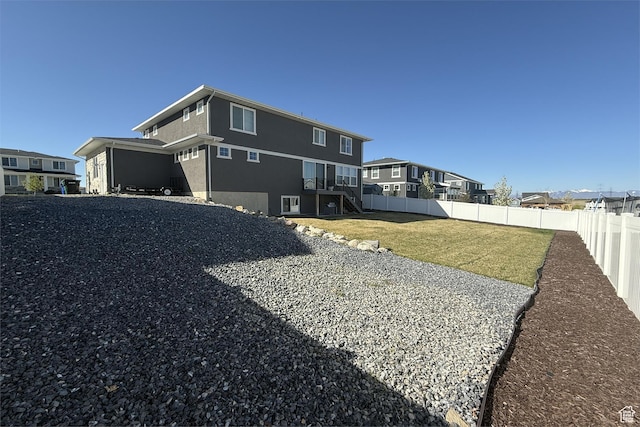 6129 W Coulee Ln, West Jordan, UT 84081 - rear view of house featuring a residential view, fence, a lawn, stairs, and stucco siding