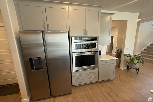 6129 W Coulee Ln, West Jordan, UT 84081 - kitchen featuring gray cabinets, light wood finished floors, light countertops, baseboards, and appliances with stainless steel finishes