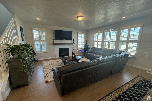 6129 W Coulee Ln, West Jordan, UT 84081 - living room featuring baseboards, a fireplace, wood finished floors, and a textured ceiling