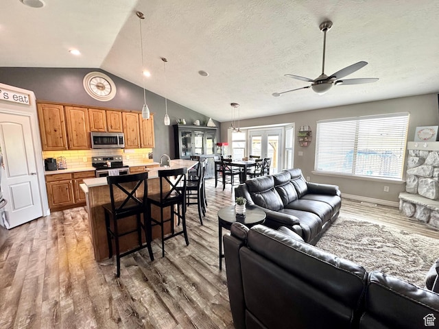 8675 N Franklin Dr E, Eagle Mountain, UT 84005 - living area with vaulted ceiling, wood finished floors, and ceiling fan