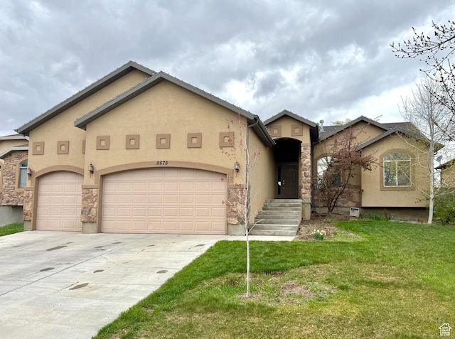 8675 N Franklin Dr E, Eagle Mountain, UT 84005 - view of front of house featuring a front lawn, driveway, stone siding, an attached garage, and stucco siding