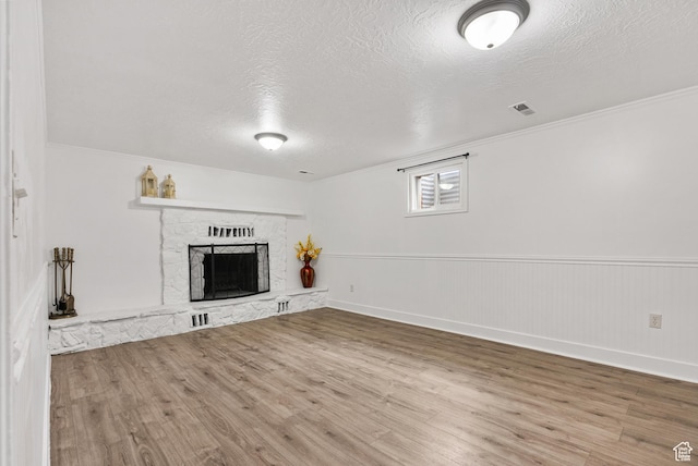 4217 S Hopi Dr, West Valley City, UT 84119 - unfurnished living room with wood finished floors, a textured ceiling, a fireplace, crown molding, and baseboards