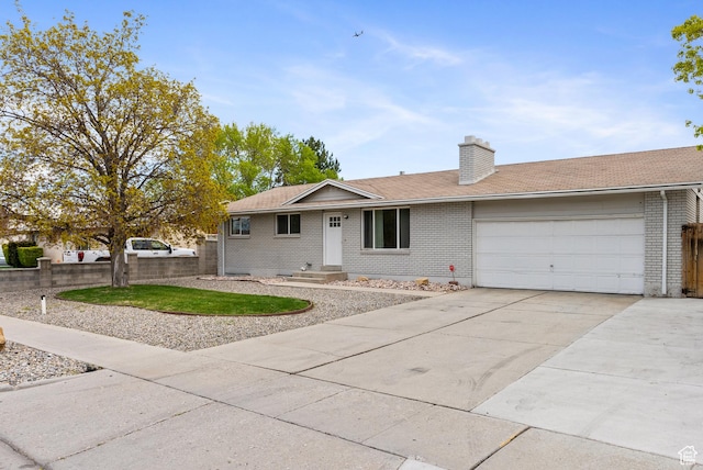 4217 S Hopi Dr, West Valley City, UT 84119 - ranch-style home featuring brick siding, a garage, driveway, and a chimney