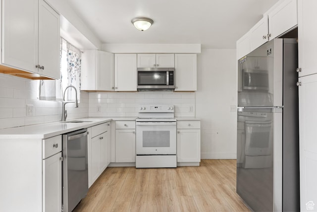 4217 S Hopi Dr, West Valley City, UT 84119 - kitchen with stainless steel appliances, a sink, light countertops, light wood finished floors, and white cabinets
