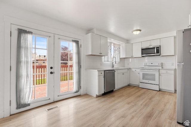4217 S Hopi Dr, West Valley City, UT 84119 - kitchen with stainless steel appliances, light countertops, decorative backsplash, light wood finished floors, and healthy amount of natural light