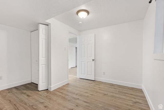 4217 S Hopi Dr, West Valley City, UT 84119 - unfurnished bedroom with baseboards, light wood finished floors, a closet, and a textured ceiling
