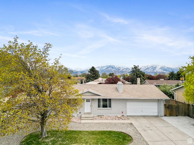 4217 S Hopi Dr, West Valley City, UT 84119 - ranch-style house featuring a chimney, an attached garage, brick siding, and a mountain view