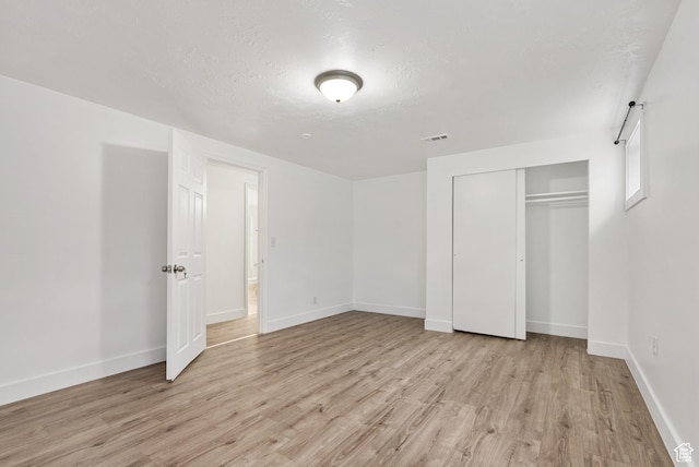 4217 S Hopi Dr, West Valley City, UT 84119 - unfurnished bedroom with light wood-style floors, a closet, baseboards, and a textured ceiling