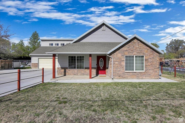 5701 S 2700 W, Roy, UT 84067 - view of front of house featuring stone siding, a garage, a porch, and driveway