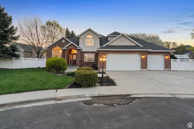 1380 S 980 E, Spanish Fork, UT 84660 - traditional-style home featuring driveway, fence, a garage, brick siding, and a lawn