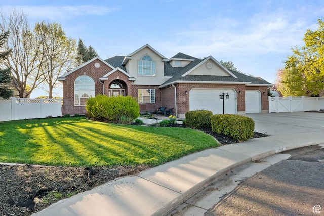 1380 S 980 E, Spanish Fork, UT 84660 - traditional-style home featuring a front lawn, driveway, an attached garage, fence, and brick siding