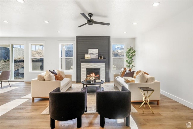 living room featuring ceiling fan, a healthy amount of sunlight, a large fireplace, and recessed lighting