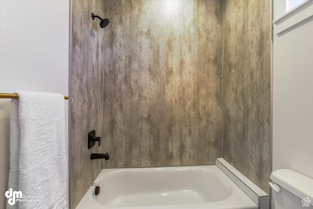 bathroom featuring shower / tub combination and toilet
