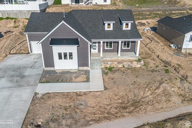 view of front of home featuring fence, a shingled roof, a porch, and concrete driveway