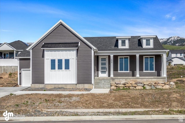 view of front of house featuring board and batten siding, an attached garage, a shingled roof, and covered porch