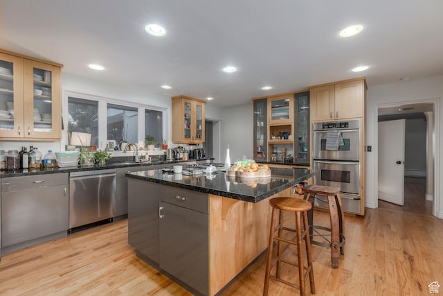 381 E 11th Ave, Salt Lake City, UT 84103 - kitchen with a baseboard heating unit, a center island, glass insert cabinets, a breakfast bar, and appliances with stainless steel finishes