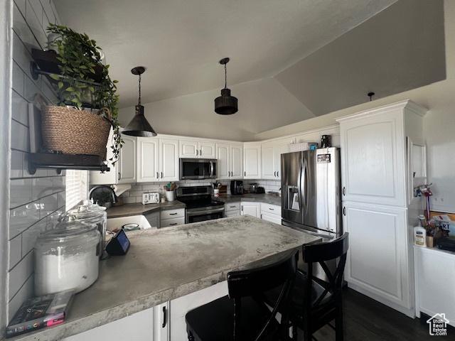 1115 Park Ridge Dr, Roosevelt, UT 84066 - kitchen with a kitchen breakfast bar, stainless steel appliances, decorative backsplash, a peninsula, and white cabinetry