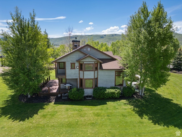 2605 E Woodland Way, Woodland, UT 84036 - view of front facade featuring a chimney, a front yard, cooling unit, and a deck with mountain view