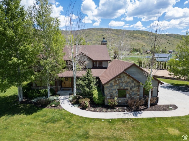 2605 E Woodland Way, Woodland, UT 84036 - view of front of house featuring stone siding, a chimney, a front yard, and driveway