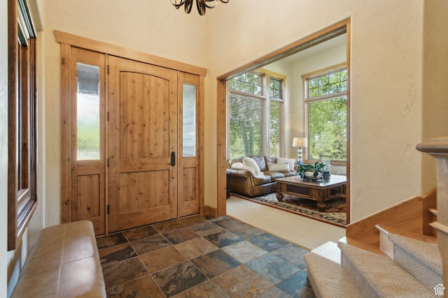 2605 E Woodland Way, Woodland, UT 84036 - foyer entrance featuring dark stone finish floors, a chandelier, and stairs