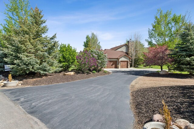 2605 E Woodland Way, Woodland, UT 84036 - view of property hidden behind natural elements featuring asphalt driveway and an attached garage
