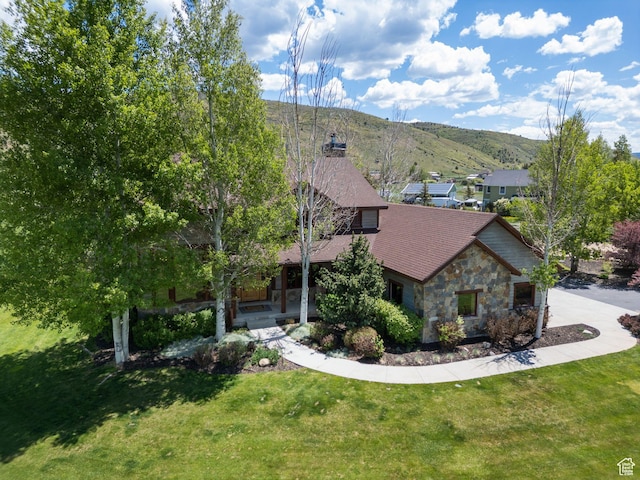 2605 E Woodland Way, Woodland, UT 84036 - view of front facade featuring stone siding, a mountain view, a front lawn, and a chimney
