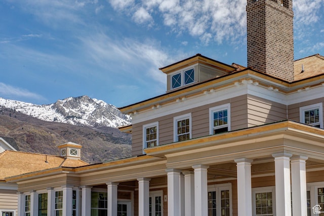 view of home's exterior featuring a chimney and a mountain view
