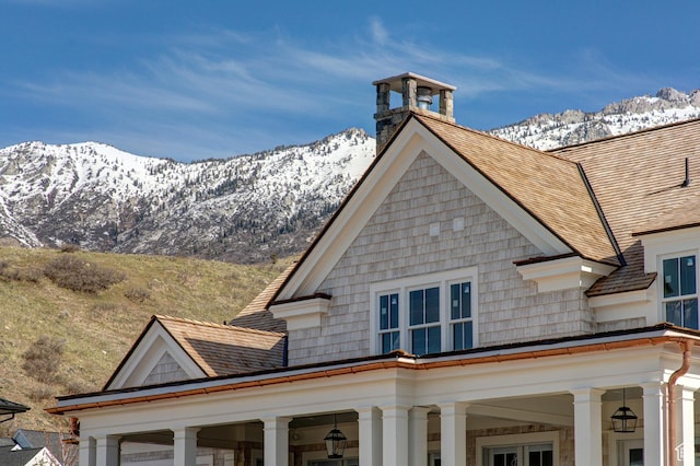 view of home's exterior with a chimney and a mountain view