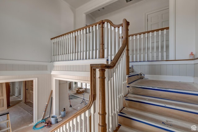 stairs featuring a decorative wall and a towering ceiling
