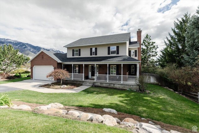 770 Orchard Dr, River Heights, UT 84321 - view of front of house with a chimney, driveway, a porch, brick siding, and a garage