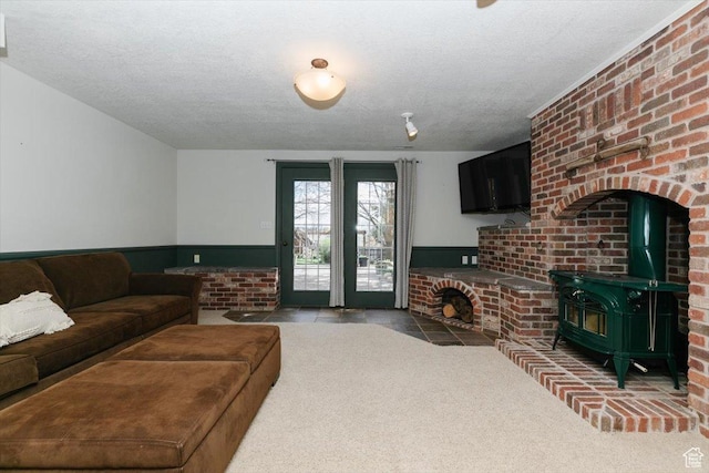 770 Orchard Dr, River Heights, UT 84321 - carpeted living room featuring wainscoting, a wood stove, and a textured ceiling