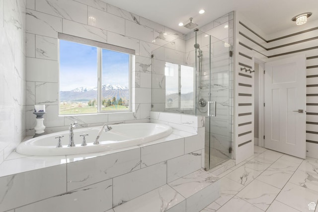 full bath featuring recessed lighting, a shower stall, marble finish floor, a mountain view, and a garden tub