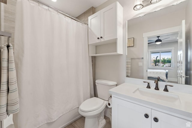 full bath with toilet, a ceiling fan, vanity, and wood finished floors