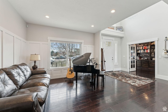 living area featuring a decorative wall, wood finished floors, and recessed lighting