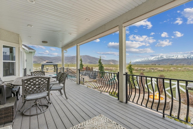 deck with outdoor dining space and a mountain view